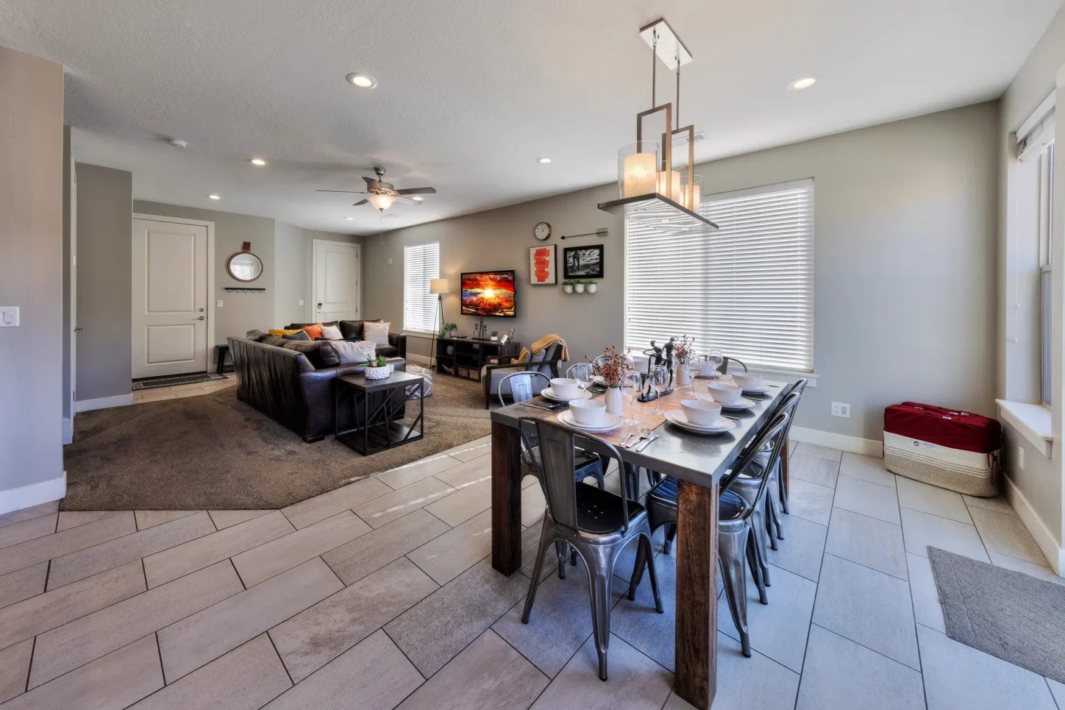 Open-concept living and dining area with eight-seat rectangular table Social dining area in Entrada Moab townhome 417 featuring an open-concept flow to the living room and natural end-unit lighting.