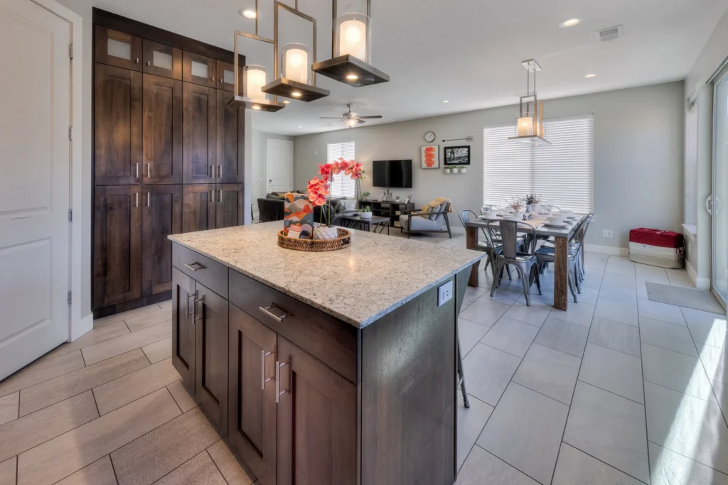 Wide-angle kitchen and dining area in an end-unit Moab townhome featuring an island and natural light from side windows.