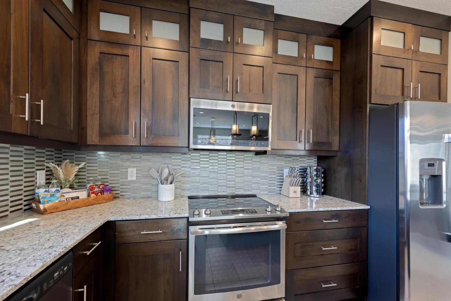 023-Entrada-Moab-417-Living-Dining-Kitchen Fully equipped kitchen with GE Profile appliances, custom wood cabinetry, and a revolving spice rack in a Moab rental.