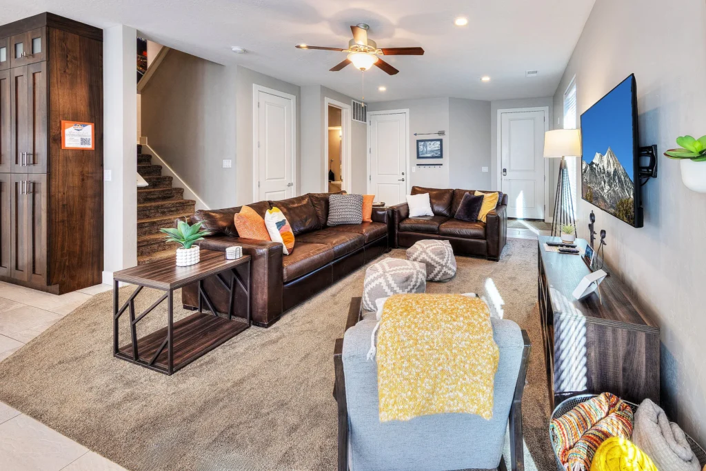 Modern living room in a Moab luxury rental with leather seating and smart TV showing Mt. Waas.