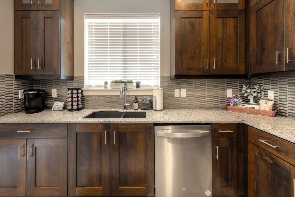 Deep kitchen sink and stainless steel dishwasher in a fully stocked Moab rental kitchen.