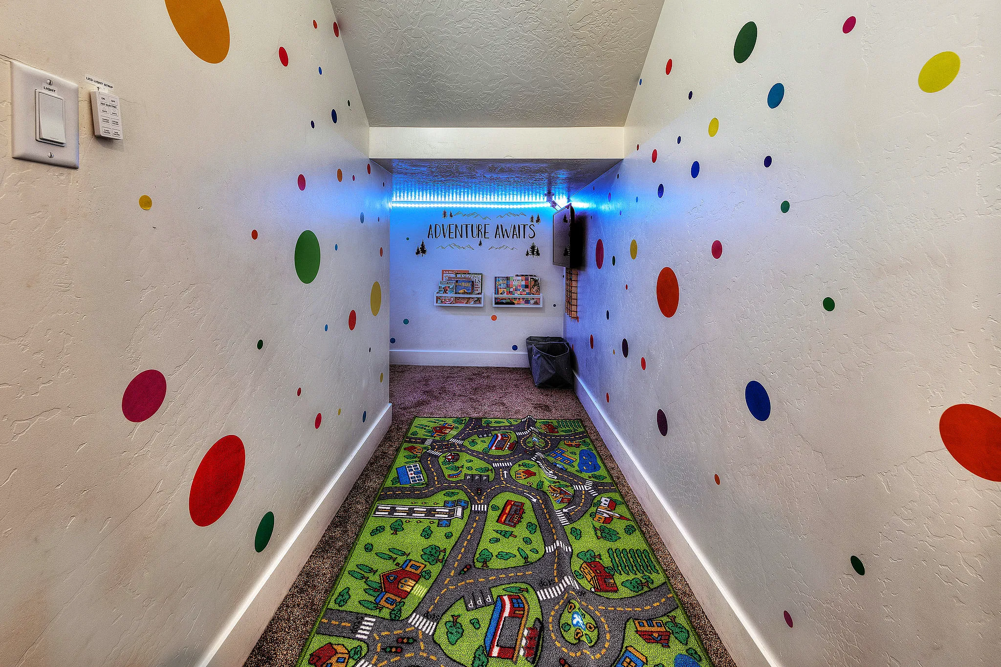Colorful "Adventure Awaits" kids' playroom under the stairs in a Moab family rental.
