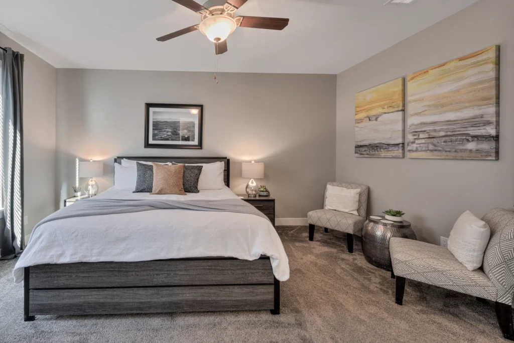 Modern master bedroom seating area in Entrada Moab with designer chairs and contemporary canyon landscape art.
