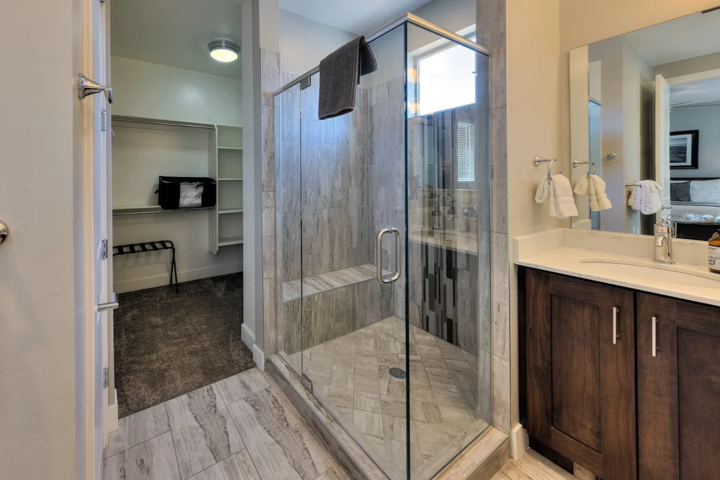 Walk-in tile shower and walk-in closet access in the master bathroom of Entrada 611.