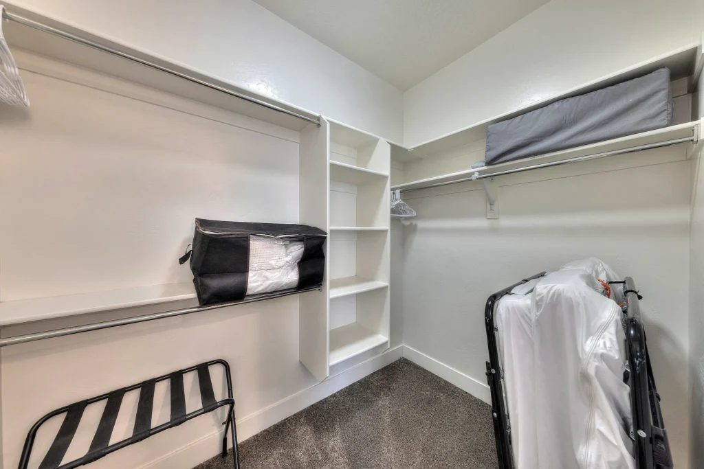 Walk-in closet in a Moab vacation rental with shelving and a roll-away bed.