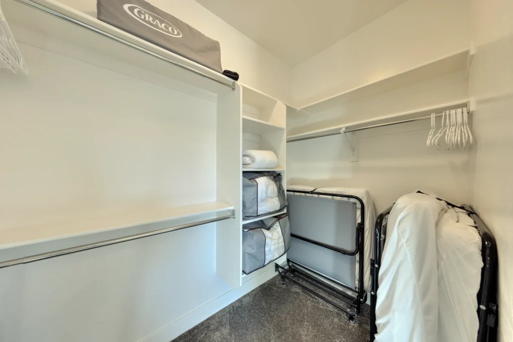 Large walk-in master closet in Entrada Moab 417 with extra roll-away beds and a Graco Pack 'n Play.