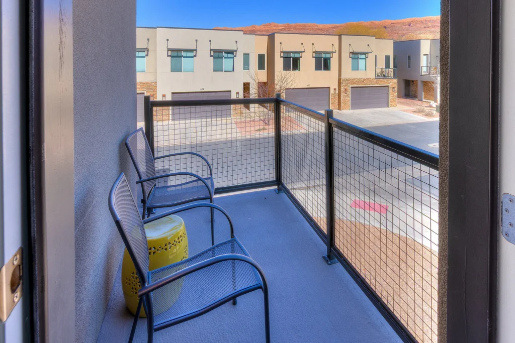 Private upstairs patio off the queen bedroom in a Moab vacation home with outdoor seating.