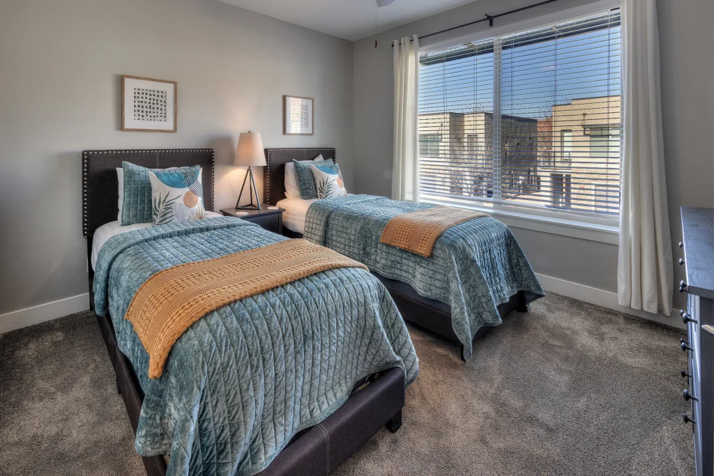 Twin bedroom with luxury bedding and large window in Entrada 611.