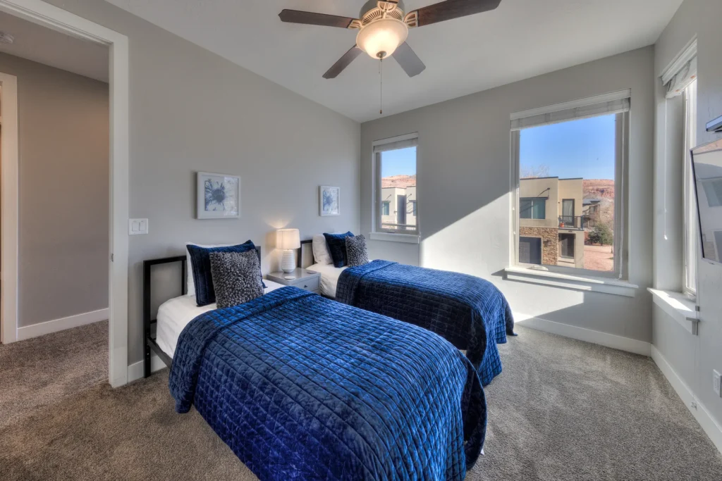 Two-twin bedroom in an Entrada Moab townhome featuring mountain views and integrated USB-C wall charging.