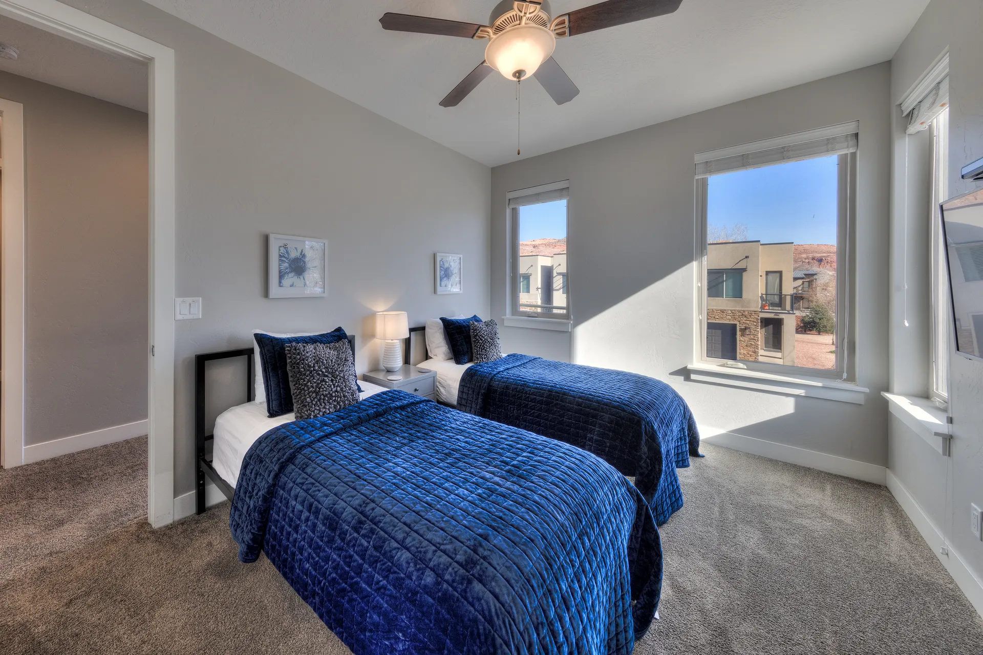 Two-twin bedroom in an Entrada Moab townhome featuring mountain views and integrated USB-C wall charging.