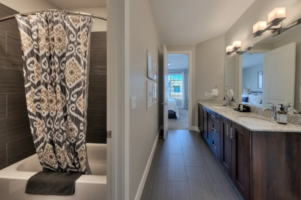 Modern Jack-and-Jill bathroom with double vanity, granite counters, and integrated night lights in Entrada Moab 417.