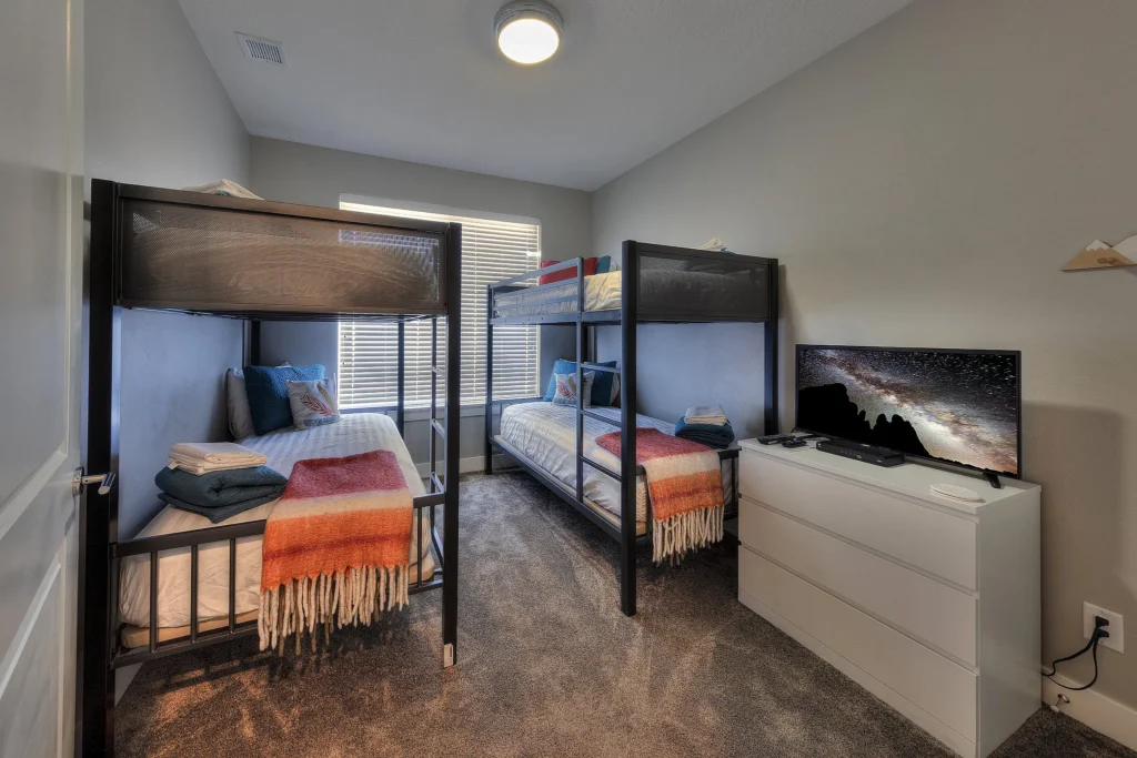 Bunk room in Entrada 611 with two twin-over-twin bunk sets and a smart TV showing the Milky Way.