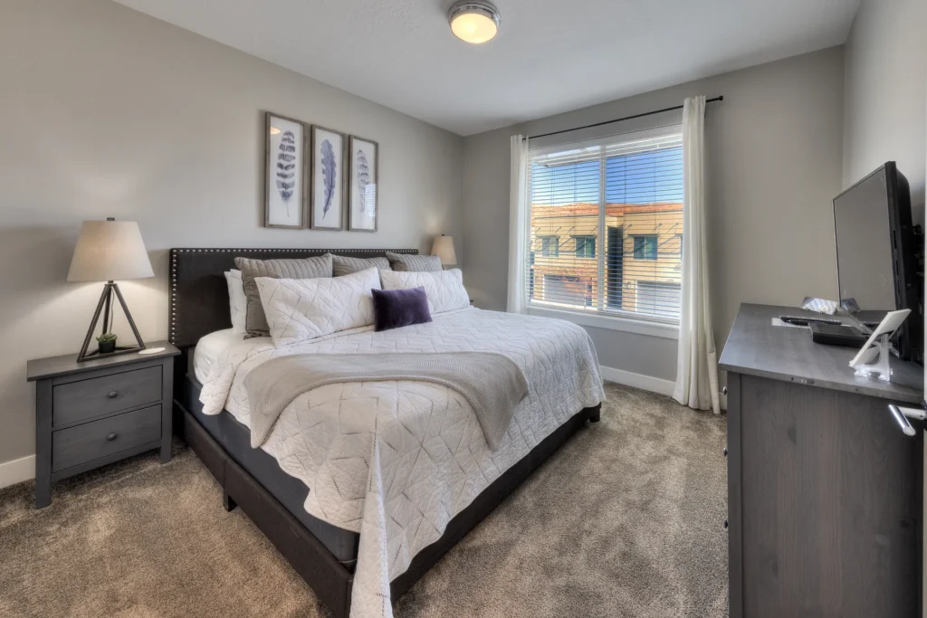 King-size bed in a premium Moab rental with integrated USB-C wall charging and high-quality window treatments.