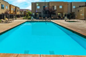 Sparkling blue community pool at Entrada Moab under a clear desert sky, viewed from the sun deck.