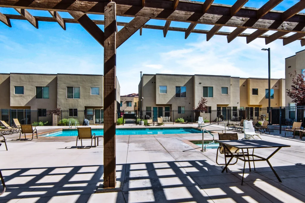 Lounge area and shaded pergola at the Entrada Moab pool deck, providing a relaxing space for guests.