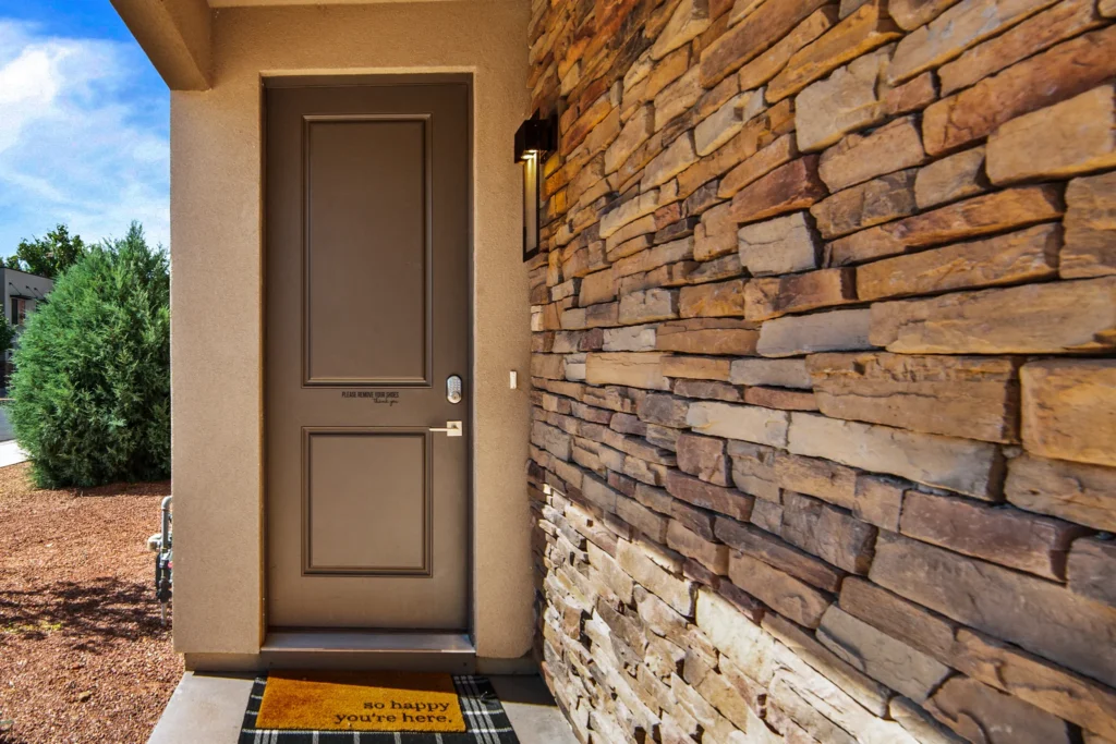 Private front entrance of Entrada 611 with a stone wall and keyless entry lock.
