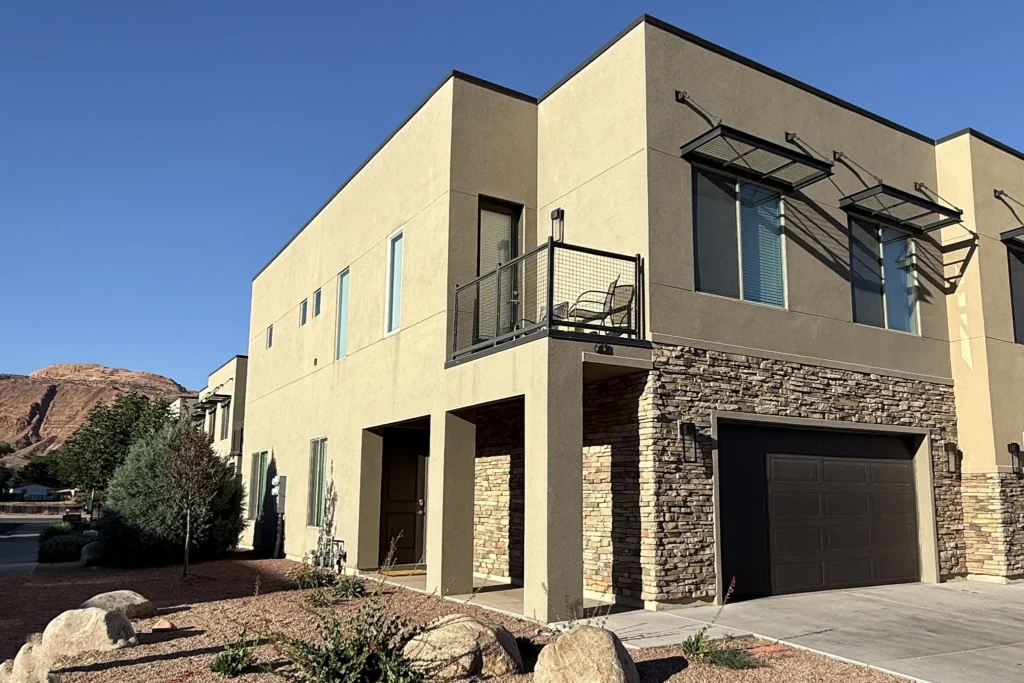 Ground-level exterior of Entrada 611 townhome showing the corner location and landscaping.