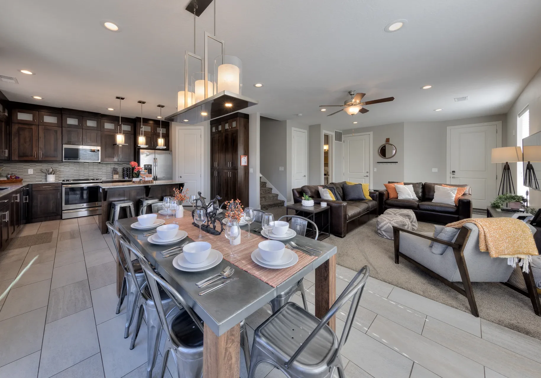 Gourmet kitchen and dining area in Moab townhome with dark wood cabinetry, breakfast bar seating, and stainless steel appliances.